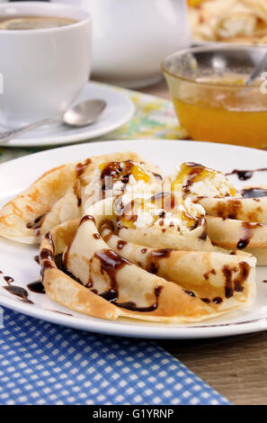 Pancake piegato nella forma di una lumaca per la ricotta con il cioccolato Foto Stock