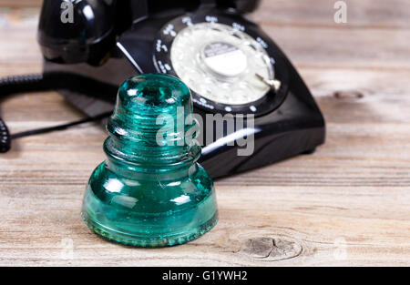 In prossimità di un antico vetro elettrico isolante con la vendemmia manuale telefono in background. Foto Stock