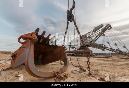 Un gigante di rusty benna nella cava di sfondo escavatore attrezzature per l'estrazione di sabbia da cava. Foto Stock