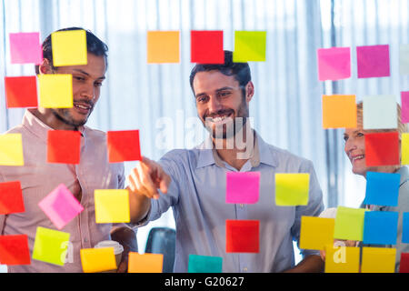 La gente di affari guardando post-it sulla parete Foto Stock