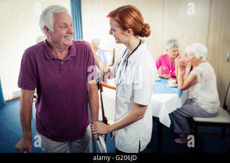 Un infermiere che assiste un senior usando un walker Foto Stock