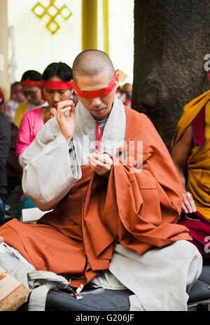 Un monaco prega durante un tibetano Chenrezig iniziazione. McLeod Ganj Dharamsala, in India. Foto Stock