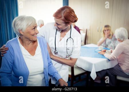 Un infermiere che assiste un senior usando un walker Foto Stock