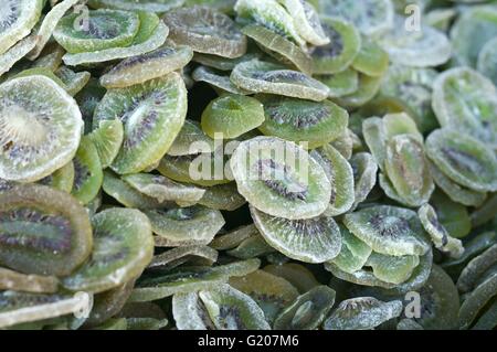 Cumulo di canditi e essiccato gustose fette di kiwi con lo zucchero per la vendita al dettaglio nel mercato alimentare. Foto Stock