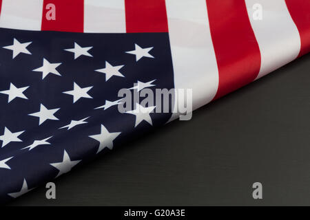 Frammento di ripiegata della bandiera americana sulla lavagna. L'immagine orizzontale con diagonale di copia dello spazio. Foto Stock