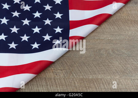 Frammento di bandiera degli Stati Uniti ripiegato su legno tavolo in legno di noce con spazio di copia Foto Stock