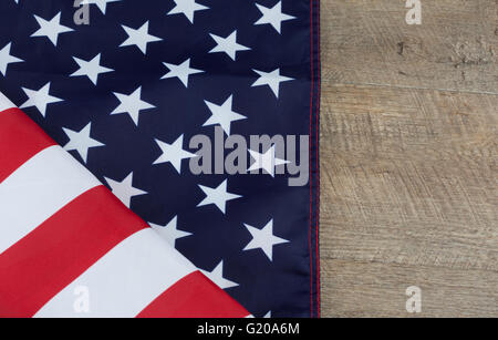 Frammento della bandiera americana ripiegata su legno tavolo in legno di noce. L'immagine orizzontale con copia spazio. Foto Stock