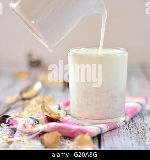 Latte di avena in un bicchiere sul tavolo con frutta Foto Stock