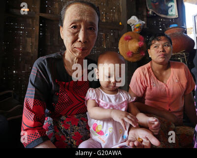 MYANMAR Hlaing Thayer, una delle baraccopoli della capitale Yangon dove le persone sono stati riposizionati dopo il 2008 Typhoon. MCHAN è attiva in questo settore con la sua comunità basata programma sanitario. Visitare una casa dove MCHAN esegue health check-up e conduce il workshop. Locali di mamme e bambini. Foto Stock