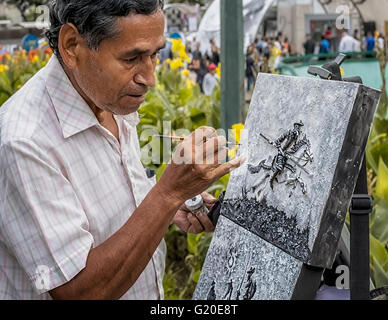 Caracas, Venezuela - 1 Maggio 2016: l'artista di strada pittura su strada in Plaza Altamira, celebrando la fiera del libro. Foto Stock