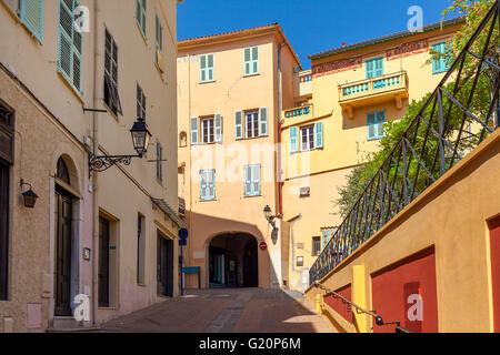 Strada stretta tra le case colorate nella città vecchia di Mentone, in Francia. Foto Stock
