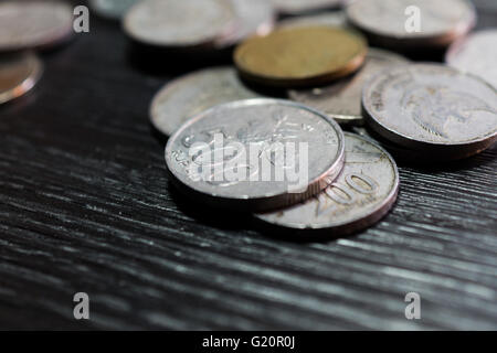 Pila di moneta di rupiah sul legno nero lo sfondo del modello Foto Stock