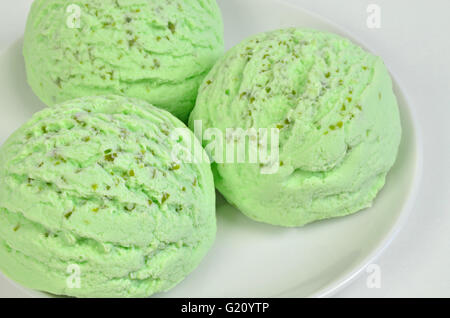 Tre palline di verde ice cream, pistacchio, Woodruff, menta piperita o aroma kiwi, sulla piastra bianca, vicino, frame completo Foto Stock