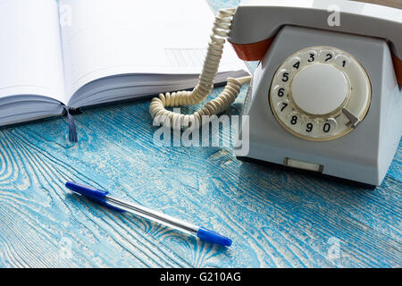 La foto illustra un telefono di rete fissa con un notebook Foto Stock