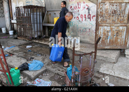 Rafah nella striscia di Gaza, Territori palestinesi. 22 Maggio, 2016. Un uomo palestinese riempie le bottiglie di plastica e taniche con acqua potabile da un pubblico tocca a Rafah nel sud della striscia di Gaza, il 22 maggio 2016 © Abed Rahim Khatib/immagini APA/ZUMA filo/Alamy Live News Foto Stock