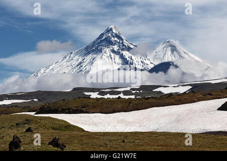 Paesaggio di montagna della Kamchatka: vista sul vulcano Kamen, attivo vulcano Klyuchevskoy e attivo vulcano Bezymianny. Foto Stock