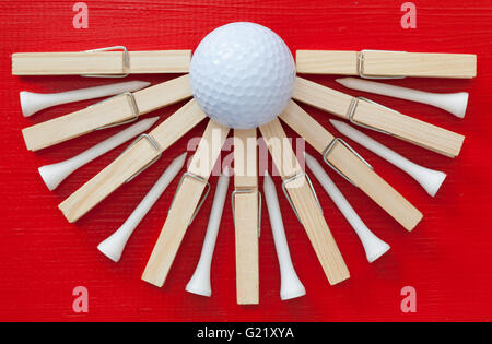 Set di spine di stoffa e pallina da golf su legno tabella rossa Foto Stock