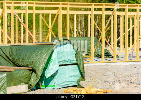 Ronneby, Svezia - 9 Maggio 2016: costruzione di una casa. I prigionieri vengono fino ma non i puntoni. Qui un pallet di legno coperto da tar Foto Stock