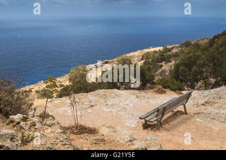Nella parte superiore della Dingli Cliffs, panca in legno con vista panoramica sul mare. Isola mediterranea di Malta. Foto Stock