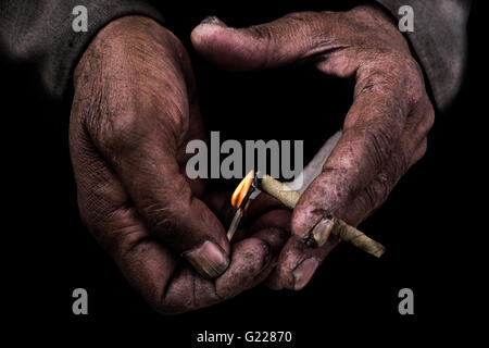 Le mani di uomo accendere una sigaretta in Delhi, India Foto Stock