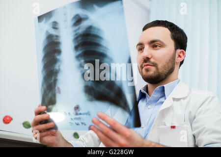 Close up ritratto di medico guardando il petto x ray nel suo ufficio Foto Stock