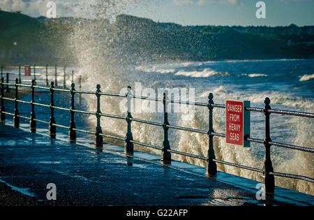 Pericolo dal mare grosso cartello di avviso sulle ringhiere a Scarborough, North Yorkshire, Regno Unito. Foto Stock