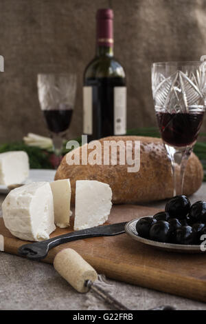 Wineglass, olive, pane e formaggio sono il saccheggio Foto Stock