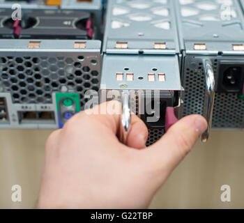 Tecnico di computer di installare unità di alimentazione sul server. Foto Stock