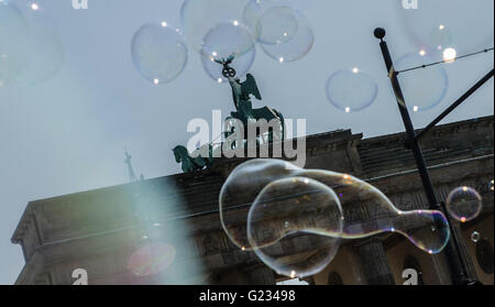 Berlino, Germania. 23 Maggio, 2016. Bolle di sapone galleggiante nella parte anteriore della porta di Brandeburgo a Berlino, Germania, 23 maggio 2016. Un polacco artista di strada sta soffiando grandi bolle di sapone fino nell'aria. Foto: PAOLO ZINKEN/dpa/Alamy Live News Foto Stock