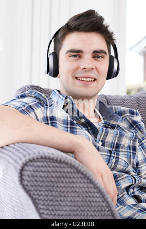 Giovane uomo ascoltare musica su cuffie senza fili Foto Stock