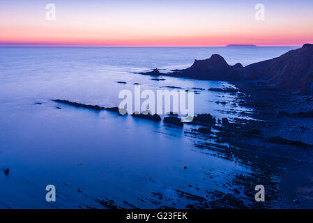 Blegberry spiaggia al tramonto su North Devon Coast con Lundy Island all'orizzonte. Hartland, Devon, Inghilterra. Foto Stock