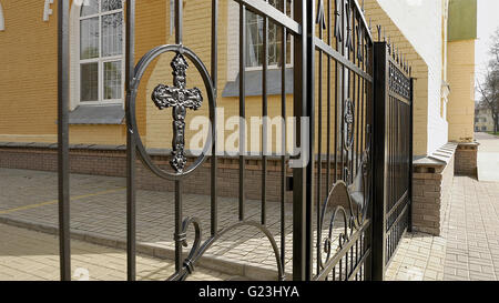 Recinzione metallica e cancello con croce del sagrato della chiesa Foto Stock
