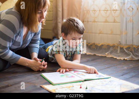 La madre è impegnato nella formazione di giovani figlio. Foto Stock