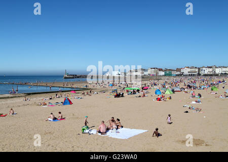 Le persone che si godono il sole in una giornata di sole a Margate Beach in East Sussex, Inghilterra Foto Stock