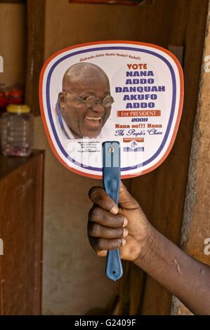 Ghana - elettore NPP sostenitore del candidato presidenziale Nana Addo, tenendo un mini poster fino a mostrare il proprio sostegno. Elezione di Ghana Foto Stock