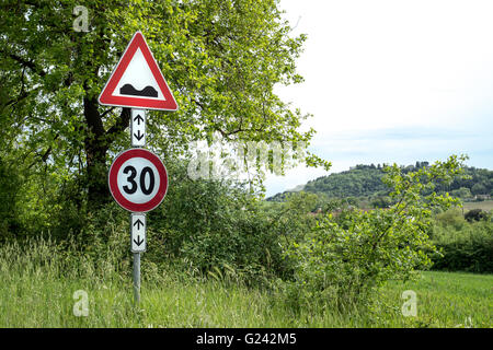 Cartello stradale attenzione Dossi davanti al prato Foto Stock