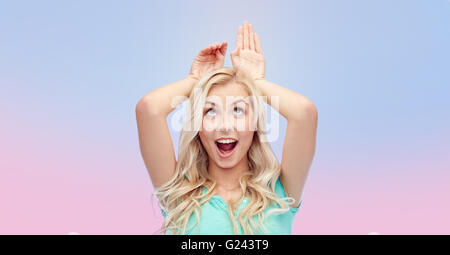 Sorridenti giovane donna fare orecchie di coniglietto Foto Stock