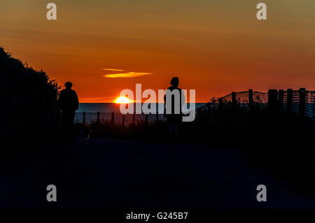 La gente guarda il tramonto sull'oceano in Cornovaglia, England, Regno Unito Foto Stock