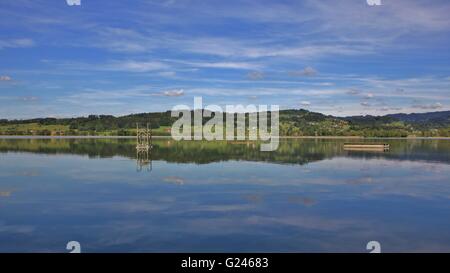 Verdi colline mirroring in Lago Pfaffikon. La molla di scena nel Cantone di Zurigo, Svizzera. Foto Stock
