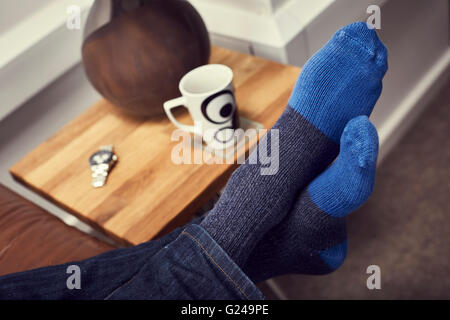 Il relax sul divano con i piedi fino Foto Stock