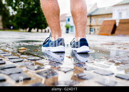 Close up di gambe di un irriconoscibile runner, città, pozza Foto Stock