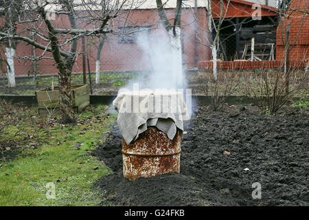 Affumicatoio casalingo in giardino. L'inverno. Il fumo. Foto Stock