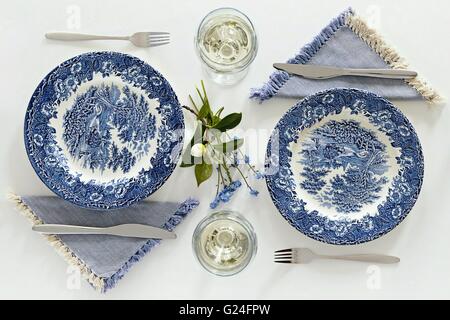 Per le placche vuote e bicchieri di vino, cena romantica per due. Un'atmosfera casalinga pulire tavolo bianco. Vista superiore Foto Stock