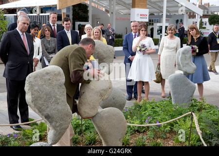 Il Duca di York (sinistra), la principessa Eugenie (terza a destra) e la Principessa Beatrice (destra) guardare una pietra stand di bilanciamento dello scultore Adrian Gray durante una visita alla RHS Chelsea Flower Show, presso il Royal Hospital Chelsea, Londra. Foto Stock