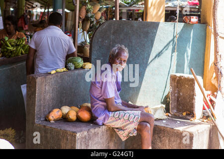 Tangalle , città nel distretto di Hambantota, sud della provincia, Sri Lanka, un uomo si siede nell'area di mercato Foto Stock