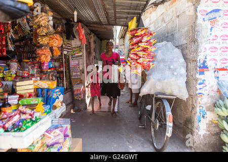 Tangalle , città nel distretto di Hambantota, sud della provincia, Sri Lanka, una donna e bambino a piedi attraverso la zona del mercato Foto Stock