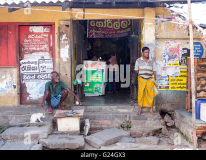 Tangalle , città nel distretto di Hambantota, sud della provincia, Sri Lanka. Scena di strada - 2 uomini stand in una porta vicino alla fermata del bus stazio Foto Stock