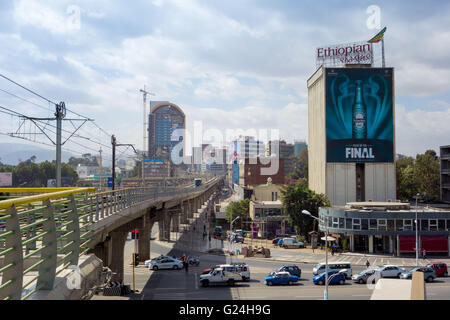 Un trafficato incrocio ad Addis Abeba, Etiopia. Una ferrovia leggera sopraelevata passa sopra le strade sottostanti Foto Stock