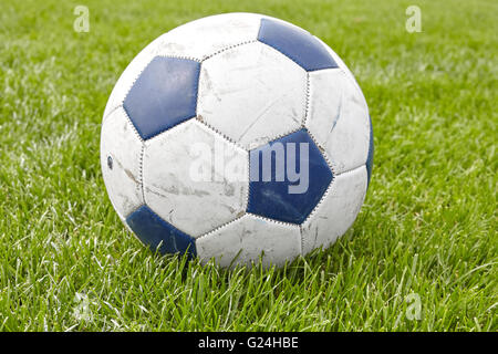 Chiudere l immagine di una pelle usato pallone da calcio in erba. Foto Stock