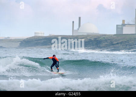 Surfer il Sandside Bay con Dounreay reattore nucleare in background Foto Stock